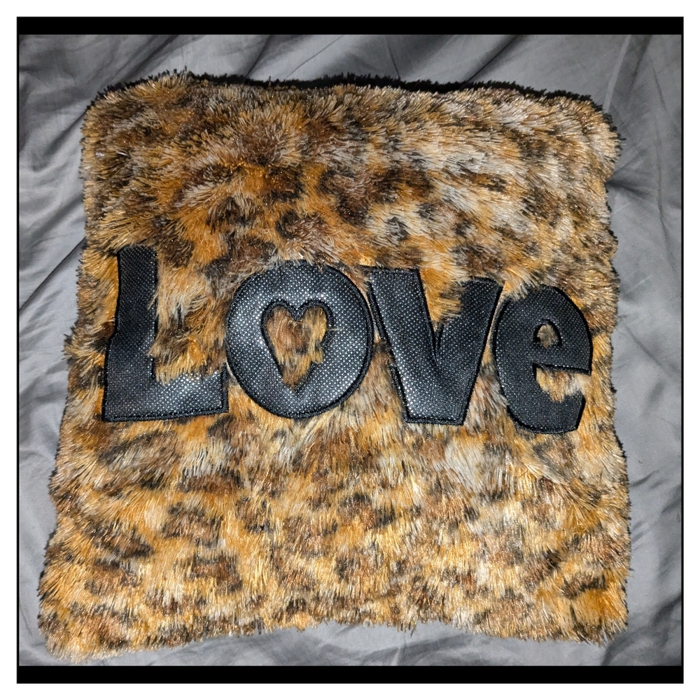 Cheetah print throw pillow with "LOVE" on it